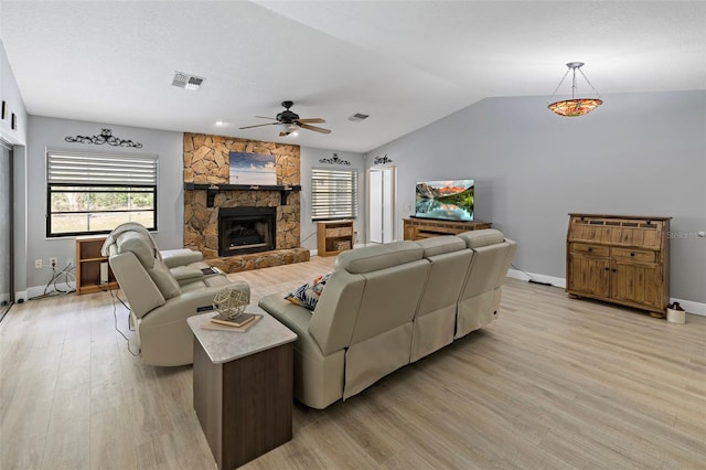 living room featuring light wood finished floors, a fireplace, and visible vents