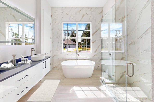 bathroom featuring vanity, a healthy amount of sunlight, independent shower and bath, and tile walls