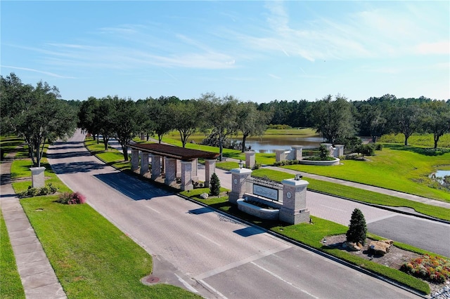 view of community featuring a lawn and a water view