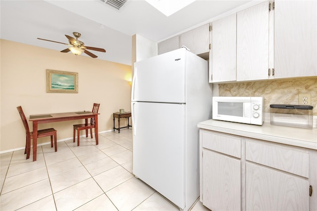 kitchen with light tile patterned flooring, ceiling fan, white appliances, and tasteful backsplash