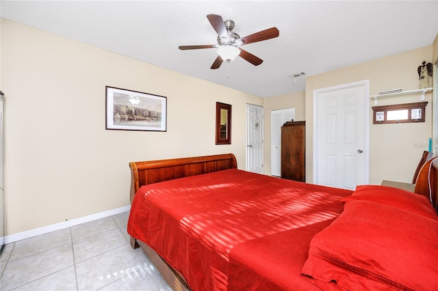 bedroom featuring ceiling fan, a textured ceiling, and light tile patterned floors