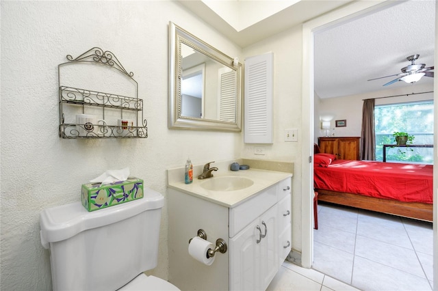 bathroom with tile patterned floors, toilet, vanity, a textured ceiling, and ceiling fan