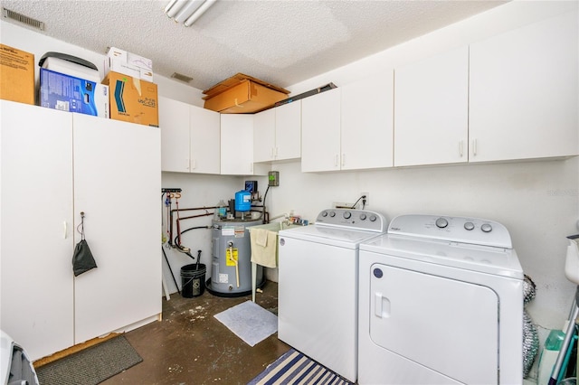 clothes washing area featuring sink, a textured ceiling, water heater, washing machine and clothes dryer, and cabinets