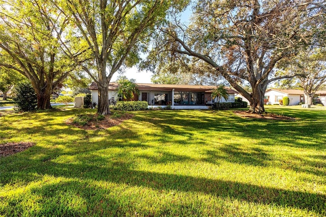 view of front of house featuring a front lawn and a sunroom