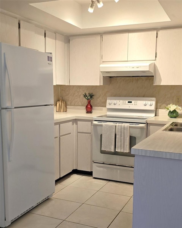 2390 Shelly Dr Unit D, Palm Harbor, FL 34684 - kitchen featuring white appliances, under cabinet range hood, a raised ceiling, light tile patterned flooring, and light countertops