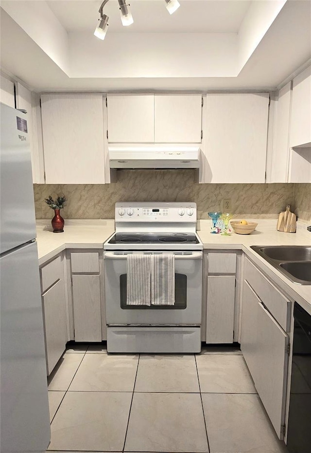 2390 Shelly Dr Unit D, Palm Harbor, FL 34684 - kitchen with white appliances, under cabinet range hood, light countertops, and light tile patterned floors