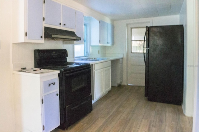 kitchen with black appliances, light hardwood / wood-style floors, and white cabinets