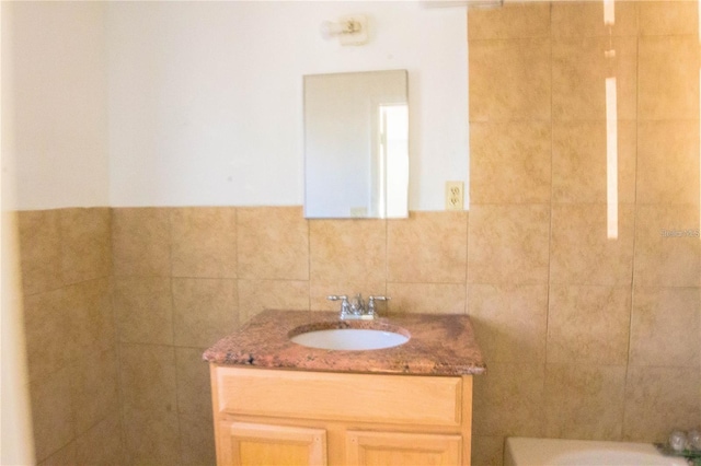 bathroom with vanity and tile walls