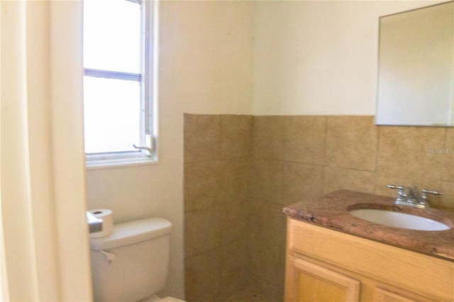 bathroom with toilet, backsplash, and vanity