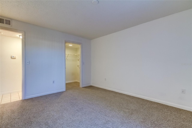 unfurnished room with a textured ceiling and carpet