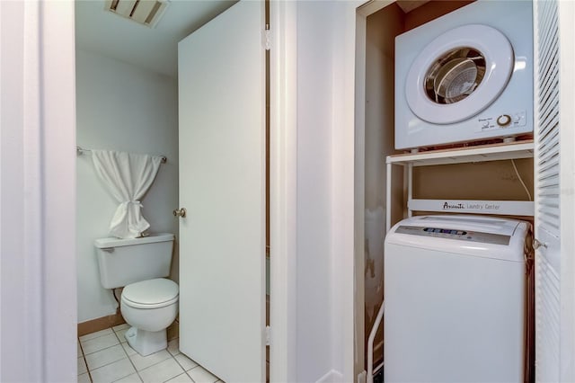 laundry area with stacked washer and clothes dryer and light tile patterned flooring