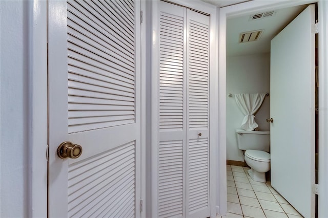 bathroom featuring toilet and tile patterned flooring