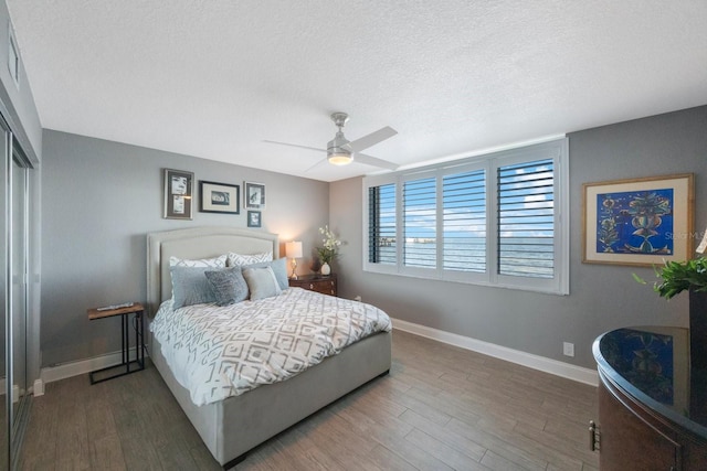 bedroom with a closet, hardwood / wood-style floors, a textured ceiling, and ceiling fan