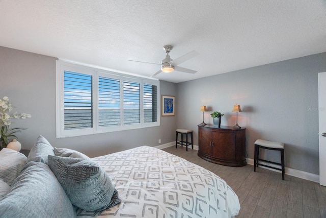 bedroom featuring ceiling fan, a textured ceiling, and dark hardwood / wood-style flooring