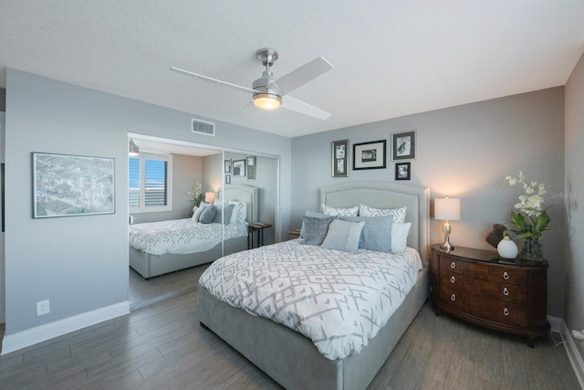 bedroom with a textured ceiling, hardwood / wood-style flooring, and ceiling fan