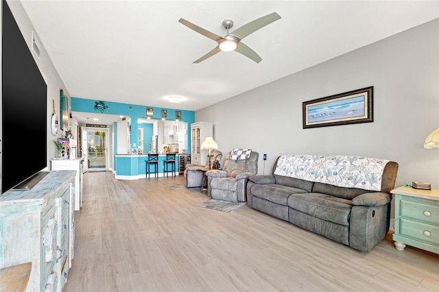 living room with ceiling fan and light hardwood / wood-style floors