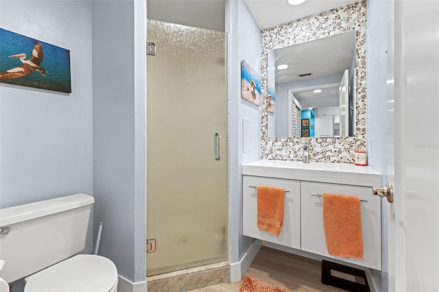 bathroom featuring backsplash, wood-type flooring, an enclosed shower, toilet, and vanity