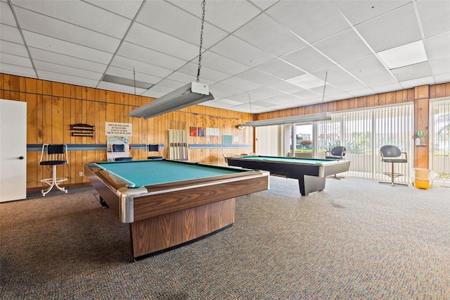 game room featuring wooden walls, a drop ceiling, dark carpet, and pool table