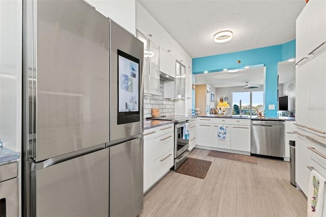 kitchen with decorative backsplash, appliances with stainless steel finishes, sink, light hardwood / wood-style flooring, and white cabinetry