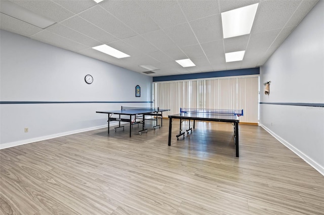 rec room with hardwood / wood-style floors and a drop ceiling