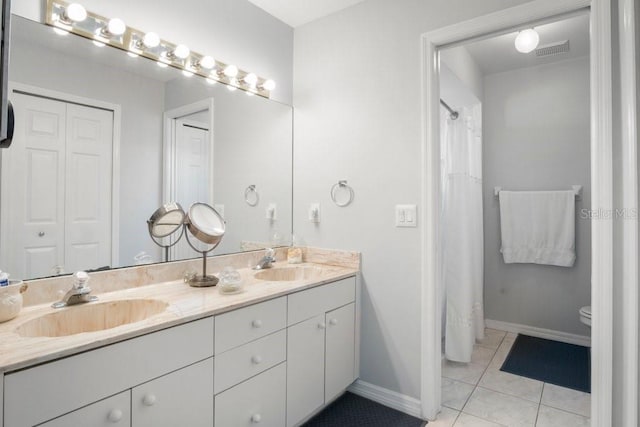 bathroom with tile patterned floors, vanity, and toilet