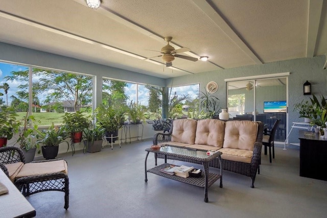 sunroom / solarium featuring ceiling fan and beamed ceiling