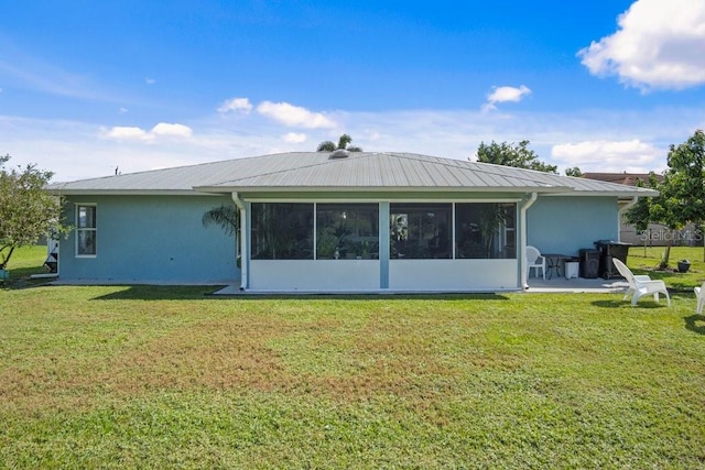 back of house featuring a sunroom, a yard, and a patio