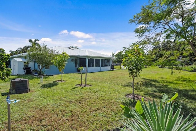 view of yard with a storage shed and a sunroom