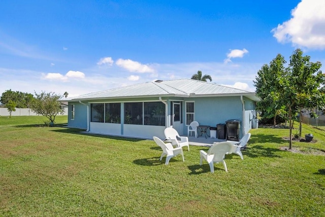 rear view of property with a sunroom and a yard