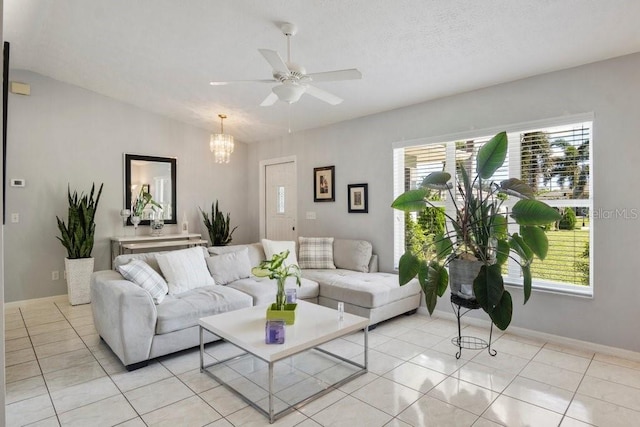 tiled living room featuring ceiling fan with notable chandelier and vaulted ceiling