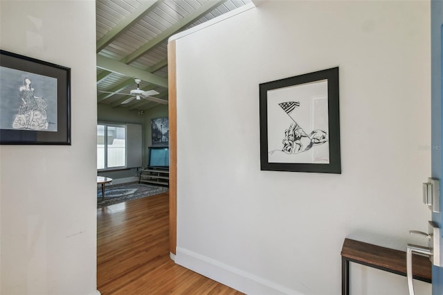 hallway featuring hardwood / wood-style floors, wooden ceiling, and beamed ceiling