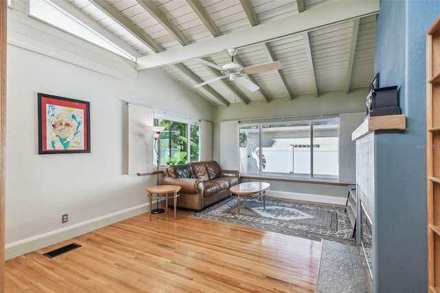 living room featuring hardwood / wood-style floors, vaulted ceiling with beams, a healthy amount of sunlight, and ceiling fan