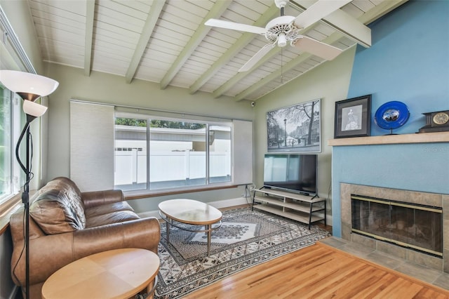 living room featuring wooden ceiling, ceiling fan, a fireplace, wood-type flooring, and vaulted ceiling with beams