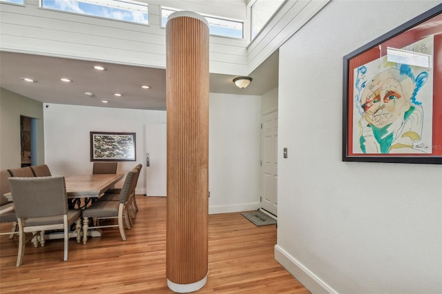 dining space featuring light hardwood / wood-style flooring and a skylight