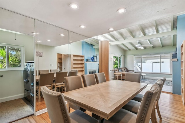 dining room with ceiling fan, vaulted ceiling with beams, washer and clothes dryer, and light hardwood / wood-style flooring