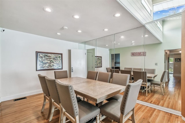 dining area featuring light hardwood / wood-style floors and a skylight