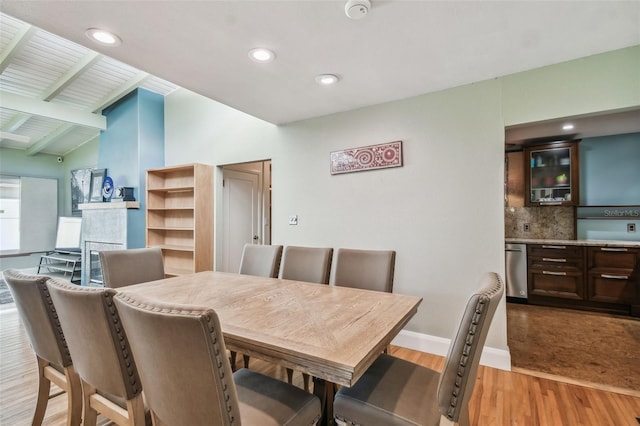 dining space featuring lofted ceiling with beams and light wood-type flooring