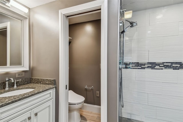 bathroom with vanity, toilet, and a shower with door