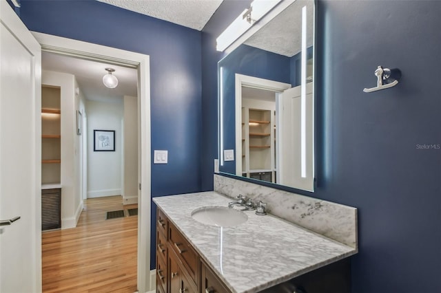 bathroom featuring vanity, a textured ceiling, and hardwood / wood-style flooring