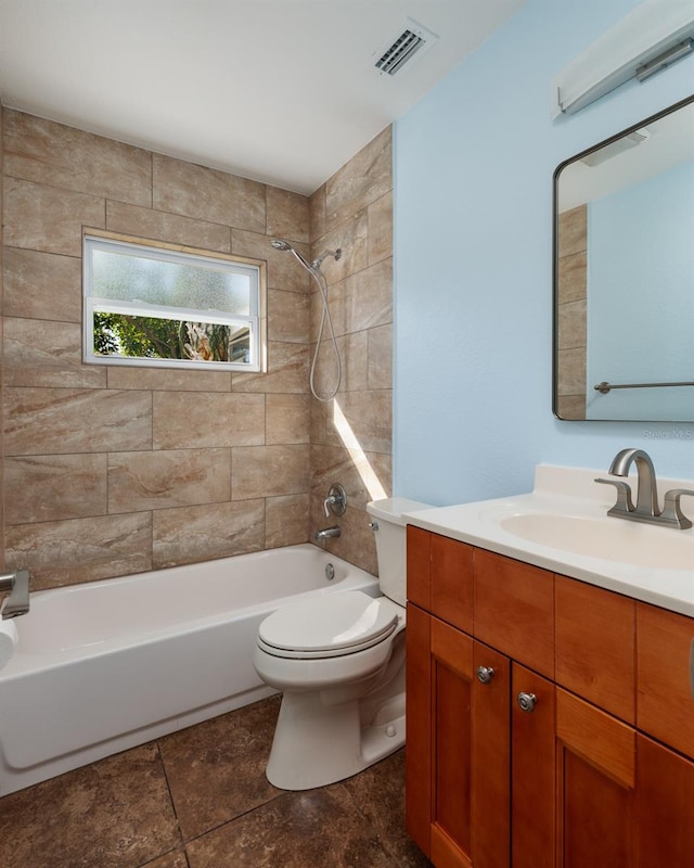 full bathroom featuring tiled shower / bath, vanity, and toilet