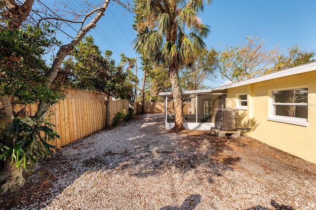 view of yard featuring a sunroom and central AC