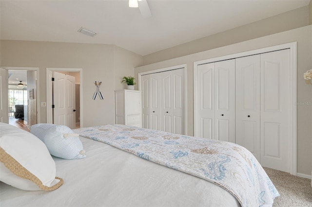 carpeted bedroom with two closets and ceiling fan