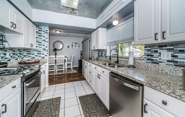 kitchen with white cabinetry, appliances with stainless steel finishes, sink, and light wood-type flooring