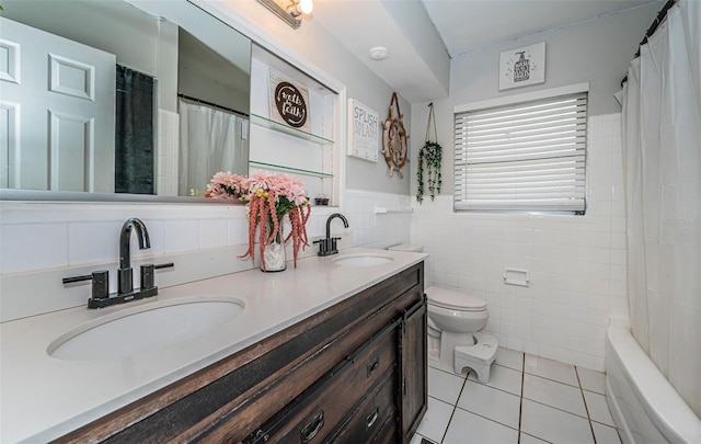 full bathroom with tile walls, toilet, vanity, shower / tub combo with curtain, and tile patterned floors