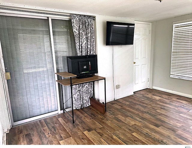 office area with dark wood-type flooring and a wood stove