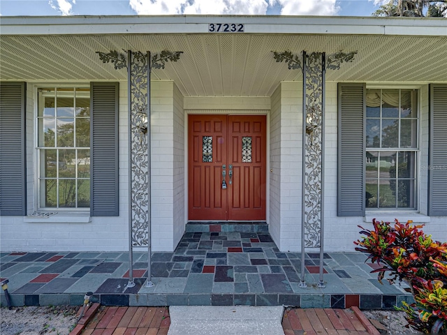 view of exterior entry featuring covered porch