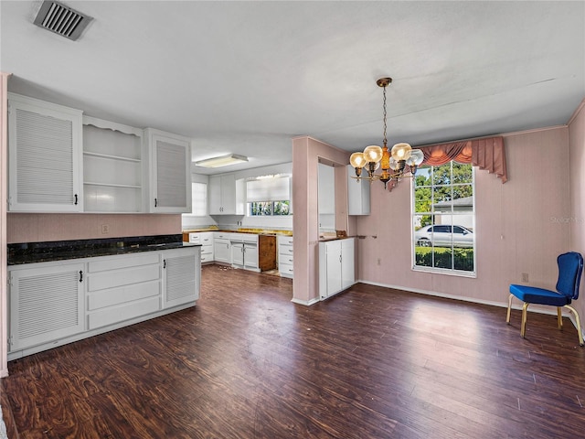 kitchen with white cabinetry, dark wood-type flooring, decorative light fixtures, and an inviting chandelier