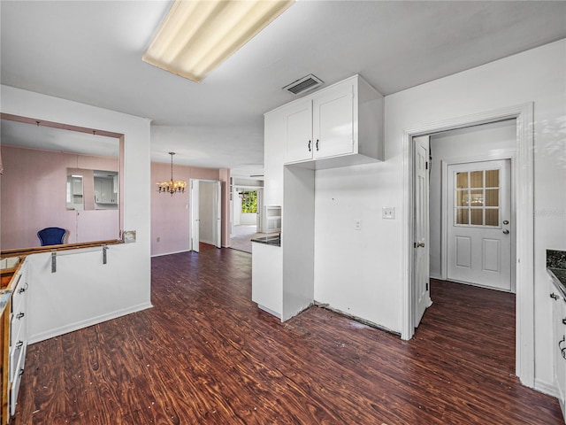 kitchen with dark hardwood / wood-style flooring, white cabinetry, hanging light fixtures, and a chandelier