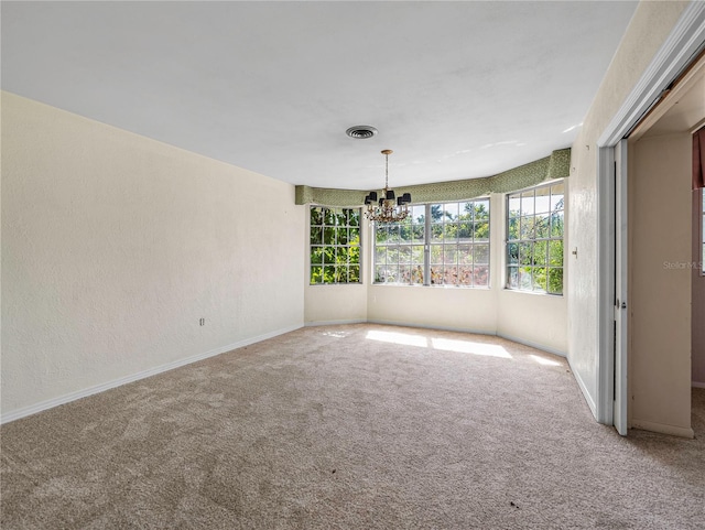 spare room featuring a notable chandelier and carpet floors