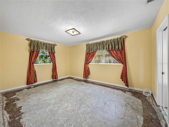 spare room featuring a wealth of natural light and a textured ceiling